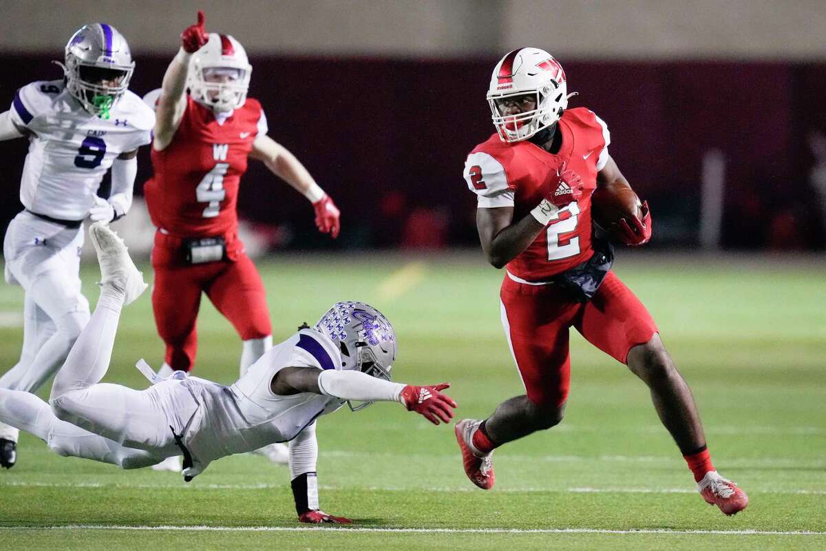 The Woodlands running back Jacoby Mitchell. Avoids the tackle of Klein Cain defensive back Isaiah Byrd, left, during the first half of a Region II-6A Division I area high school football playoff game, Friday, Nov. 18, 2022, in The Woodlands.