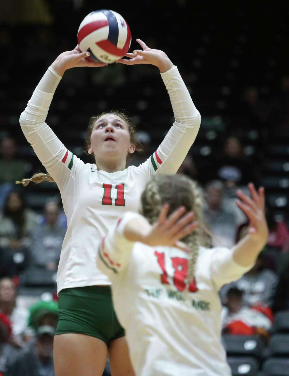 The Woodlands' Olivia Chojnacki (11) sets the ball in the second set of a Class 6A state semifinal match during the UIL State Volleyball Championships at the Curtis Culwell Center, Friday, Nov. 18, 2022, in Garland.