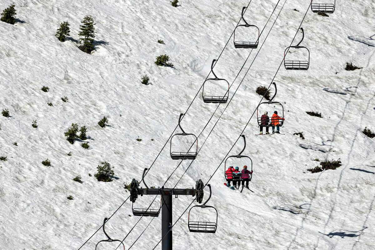 Skiers and snowboarders ride the Madden Triple Chair at Homewood Resort.