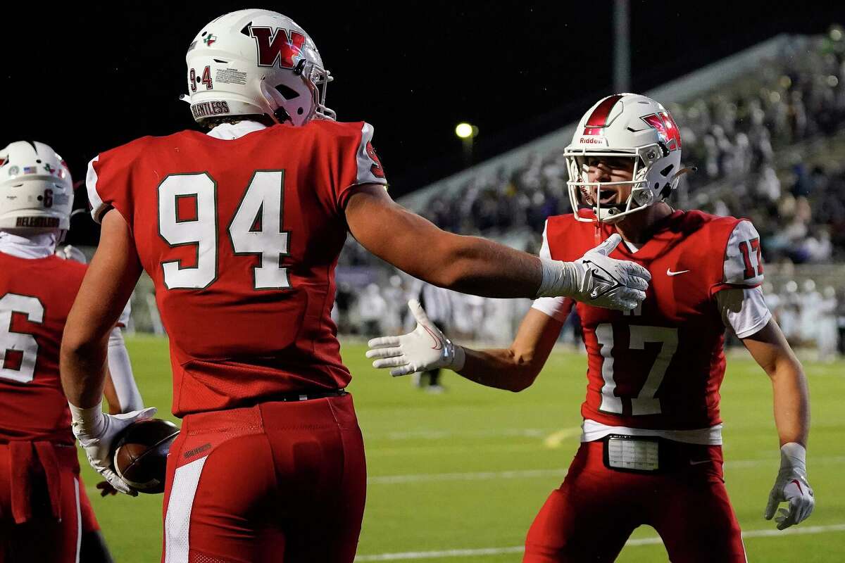 The Woodlands offensive lineman Mitchell Blakeslee (94) celebrates his touchdown with Patrick Rabel (17) during the first half of a Region II-6A Division I area high school football playoff game against Klein Cain, Friday, Nov. 18, 2022, in The Woodlands.