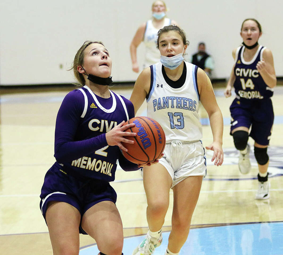 CM's Avari Combes (left) goes in for a layup ahead of Jersey's Cate Breden (13) in a game last season in Jerseyville. On Friday, the Eagles lost their season opener at the Taylorville Tourney, while the Panthers won big at home Madison in Jerseyville.