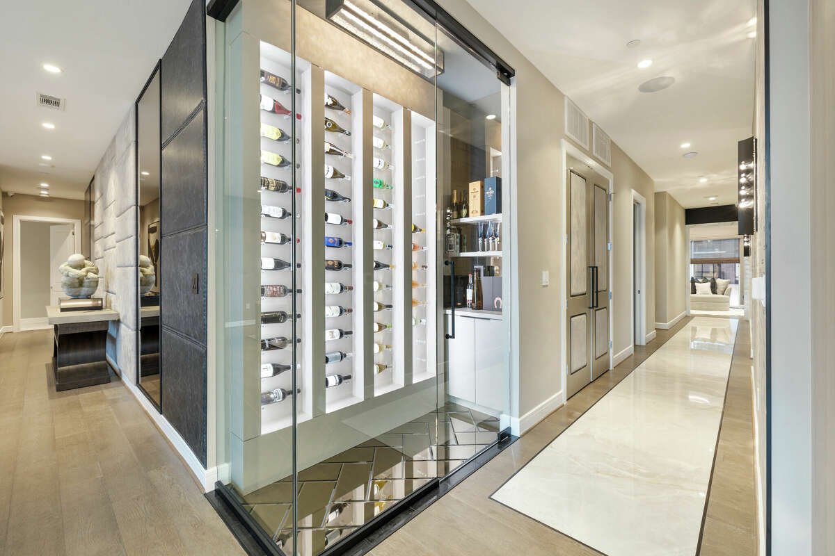 A sleek wine room sits between the living room and kitchen.