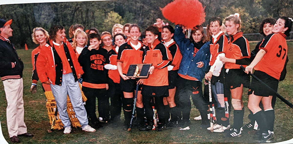 Jenny (Johnson) Norton, center, and teammate Melissa (Goff) Johnson hold the championship plaque after the Edwardsville field hockey team won the Midwest Tournament in 1988.