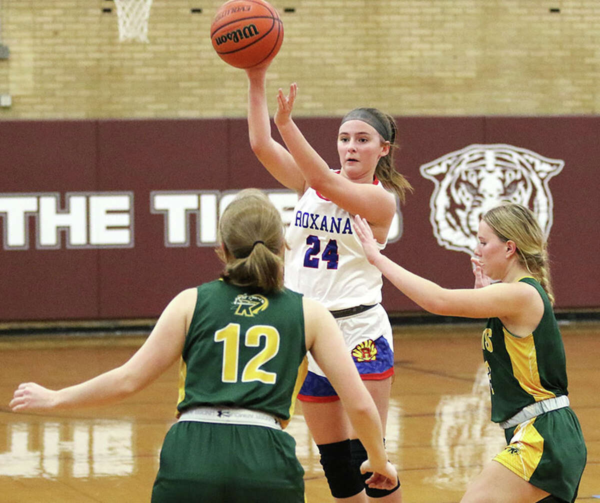Roxana's Daisy Daugherty (24) passes over Metro-East Lutheran defenders during the third-place game of the Cat Classic on Saturday in Dupo.