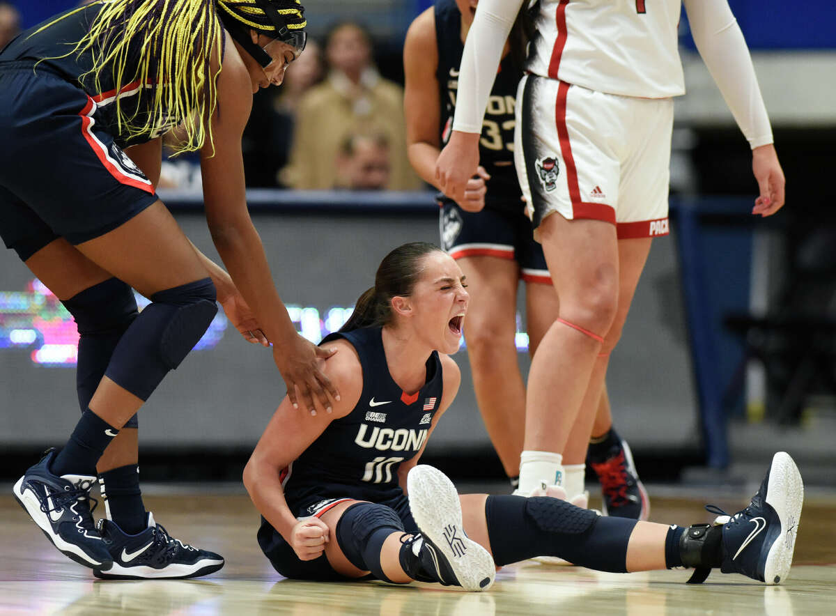 UConn guard Nika Muhl, center, celebrates with teammate Aaliyah Edwards, left, after drawing a foul in No. 5 UConn's 91-69 win over No. 10 NC State in the NCAA women's college basketball game at the XL Center in Hartford, Conn. Sunday, Nov. 20, 2022.