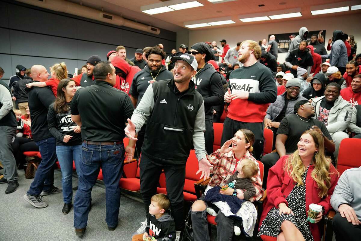 UIW head coach G.J. Kinne, along with his wife Summer and children Lincoln and Cooper, reacts during the team’s selection show watch party late Sunday morning on the campus. The Cardinals drew a first round bye.