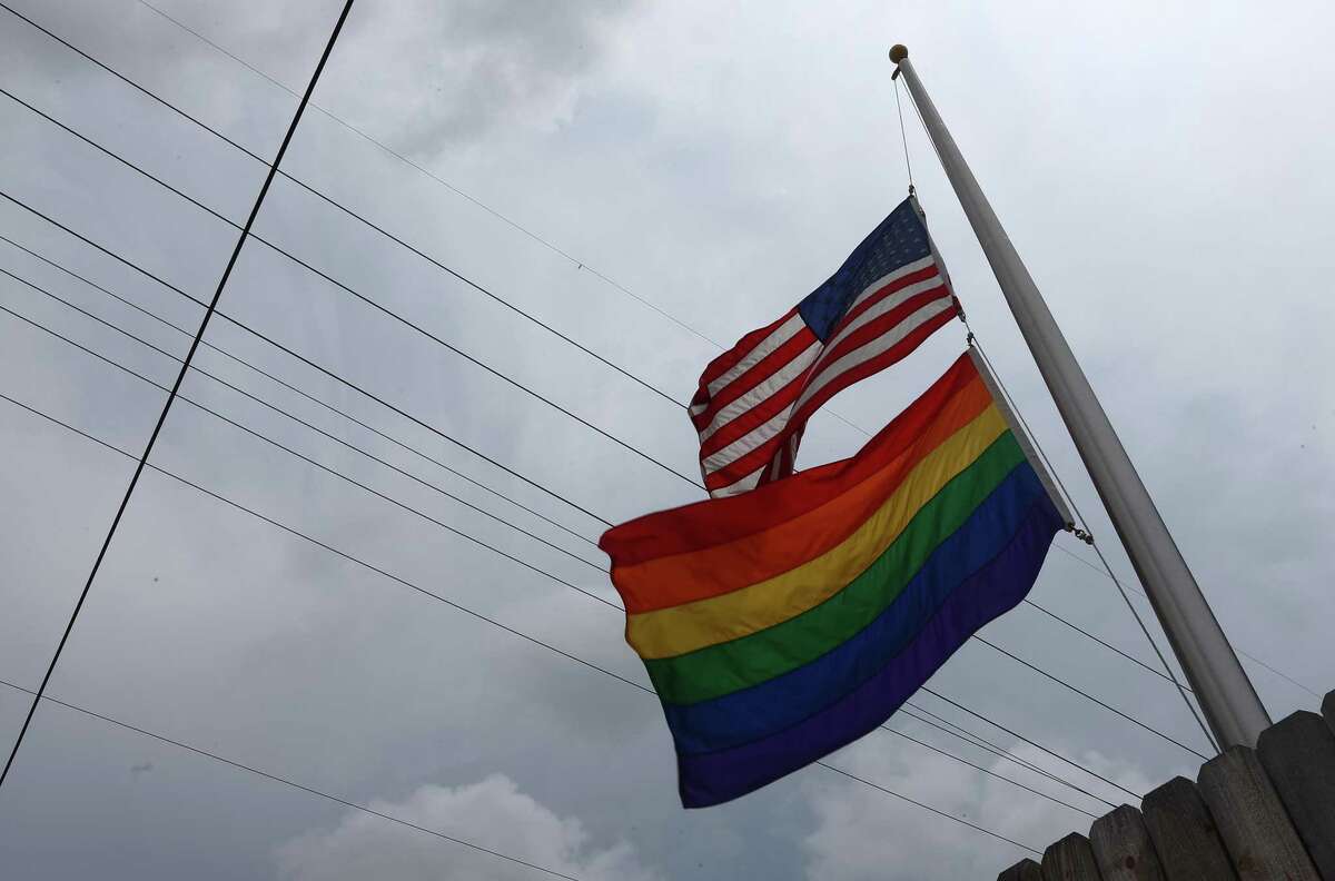 At least five people were killed and 25 more injured in a shooting at a gay nightclub Nov. 19, 2022, in Colorado Springs, Colorado. In this file photo from June 12, 2016, flags fly at half staff in front of TC's, a bar in the Montrose neighborhood, following the Pulse nightclub shooting in Orlando, Florida, which left 49 people dead and dozens more injured.