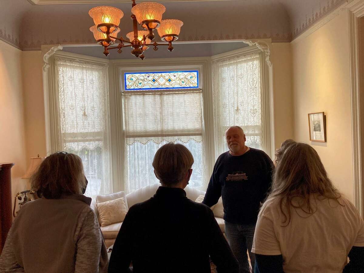 George Horsfall speaks to visitors as he begins a tour of the blue Painted Lady house to benefit artist Paul Madonna.