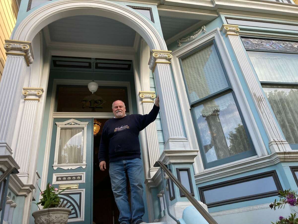 George Horsfall stands in front of his house, the blue Painted Lady on Steiner Street.