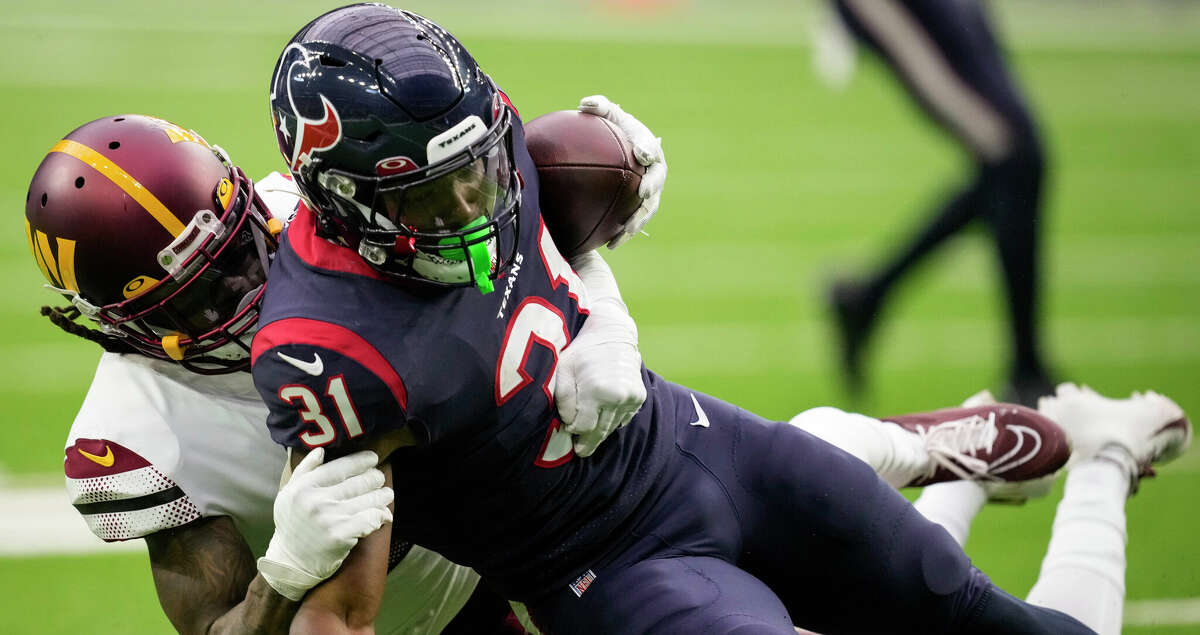 Houston Texans running back Dameon Pierce (31) is stopped for a 1-yard gain by Washington Commanders safety Bobby McCain (20) during the first half of an NFL football game Sunday, Nov. 20, 2022, in Houston.