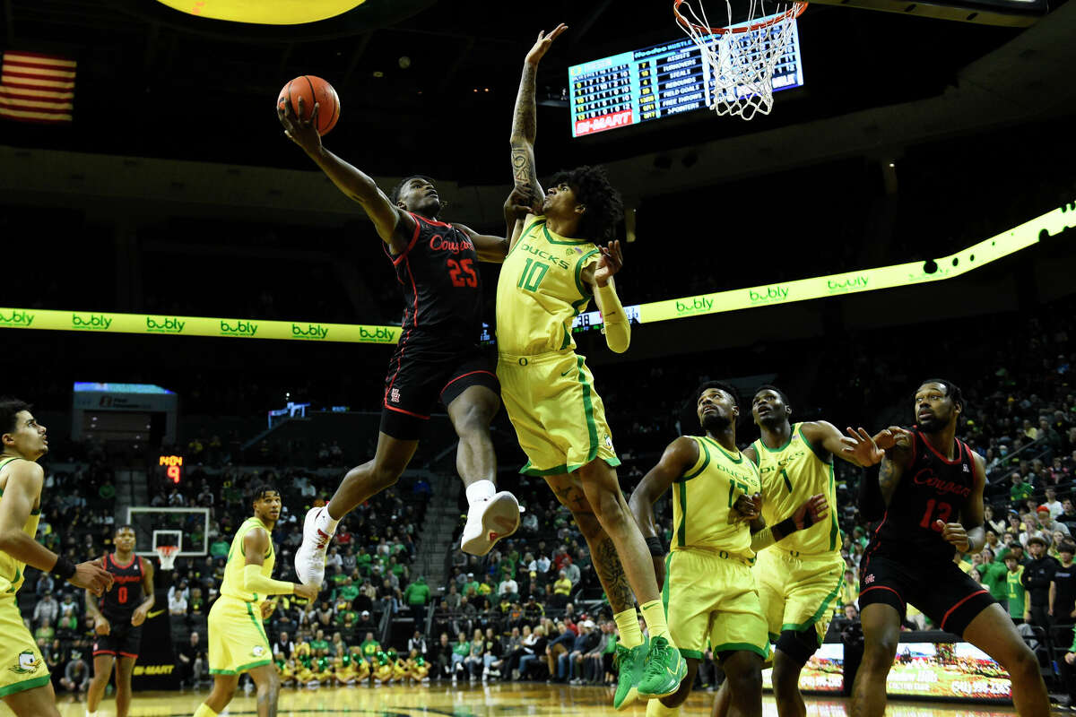 Houston forward Jarace Walker (25) drives the lane as he is defended by Oregon center Kel'el Ware (10) during the second half of an NCAA college basketball game Sunday, Nov. 20, 2022, in Eugene, Ore. (AP Photo/Andy Nelson)