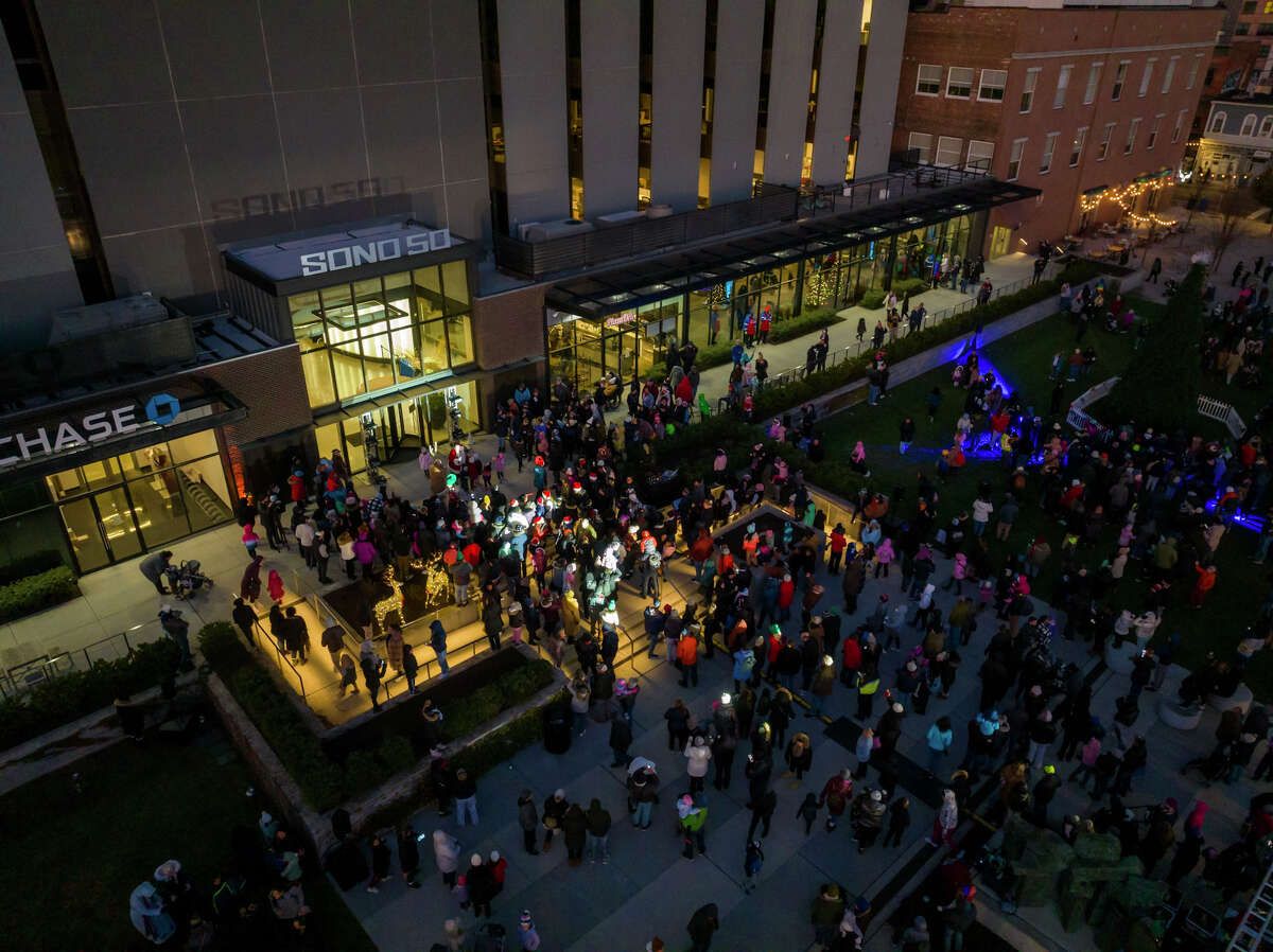A crowd gathers outside 50 Washington Street on Sunday for the first SoNo Holiday Extravaganza.  The event included tree and menorah lighting ceremonies and other family activities.