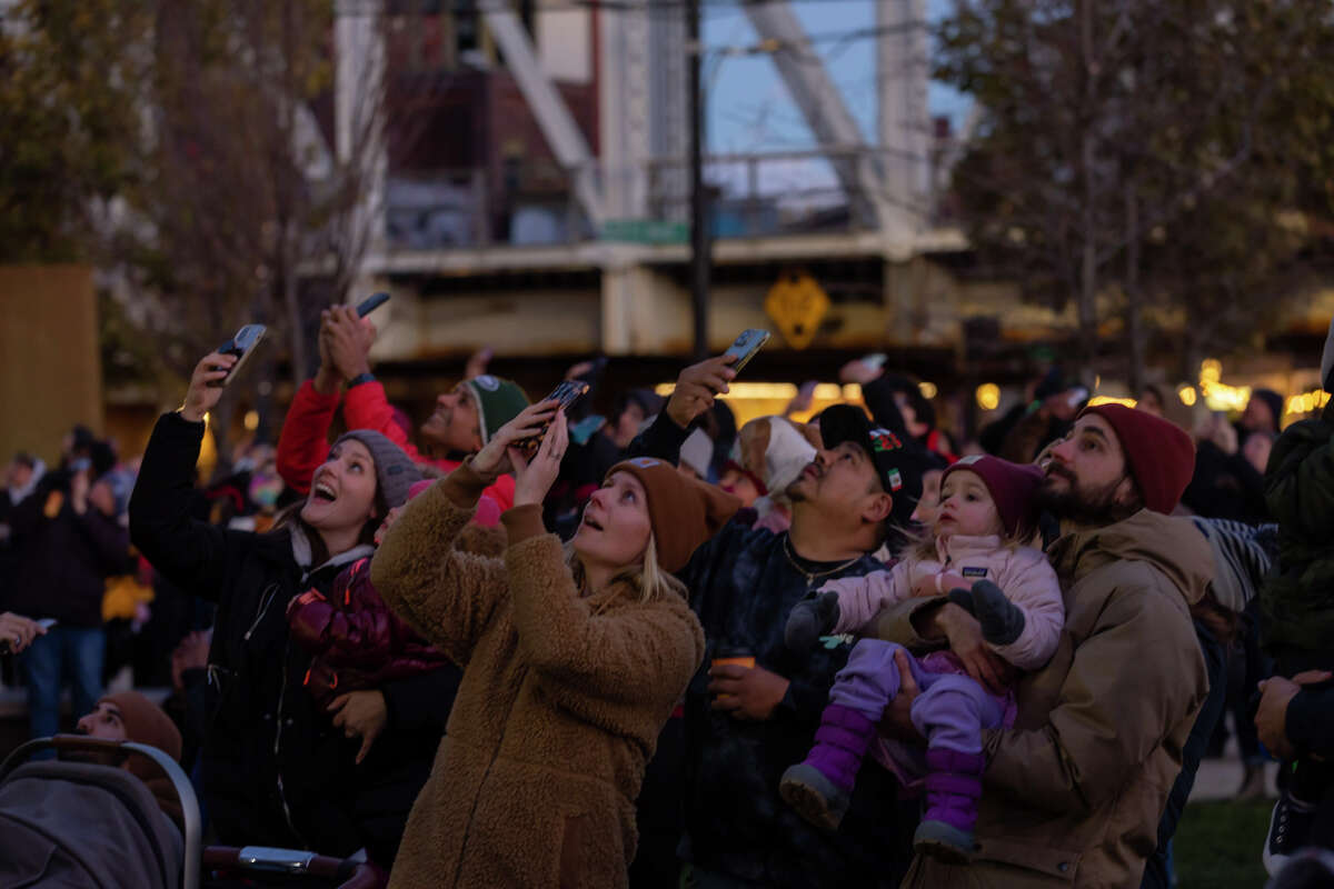 A crowd watches as Santa Claus rappels down 50 Washington St. at the first SoNo Holiday Extravaganza on Sunday. The event included tree and menorah lighting ceremonies and other family activities.