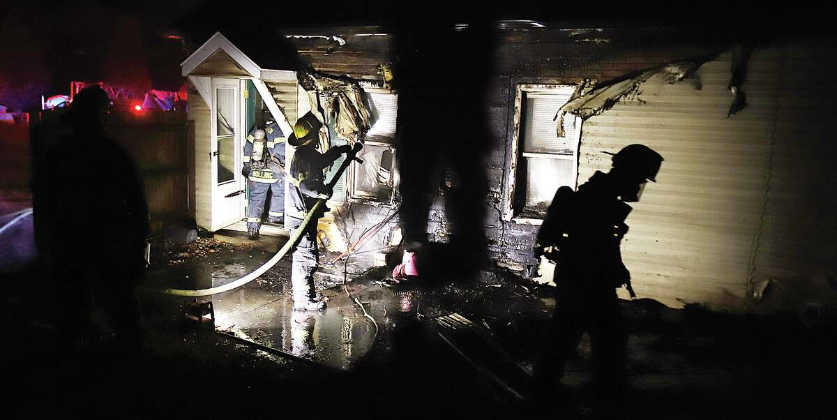John Badman|The Telegraph Firefighters begin to overhaul the damaged rear of an Alton house after the flames were extinguished.