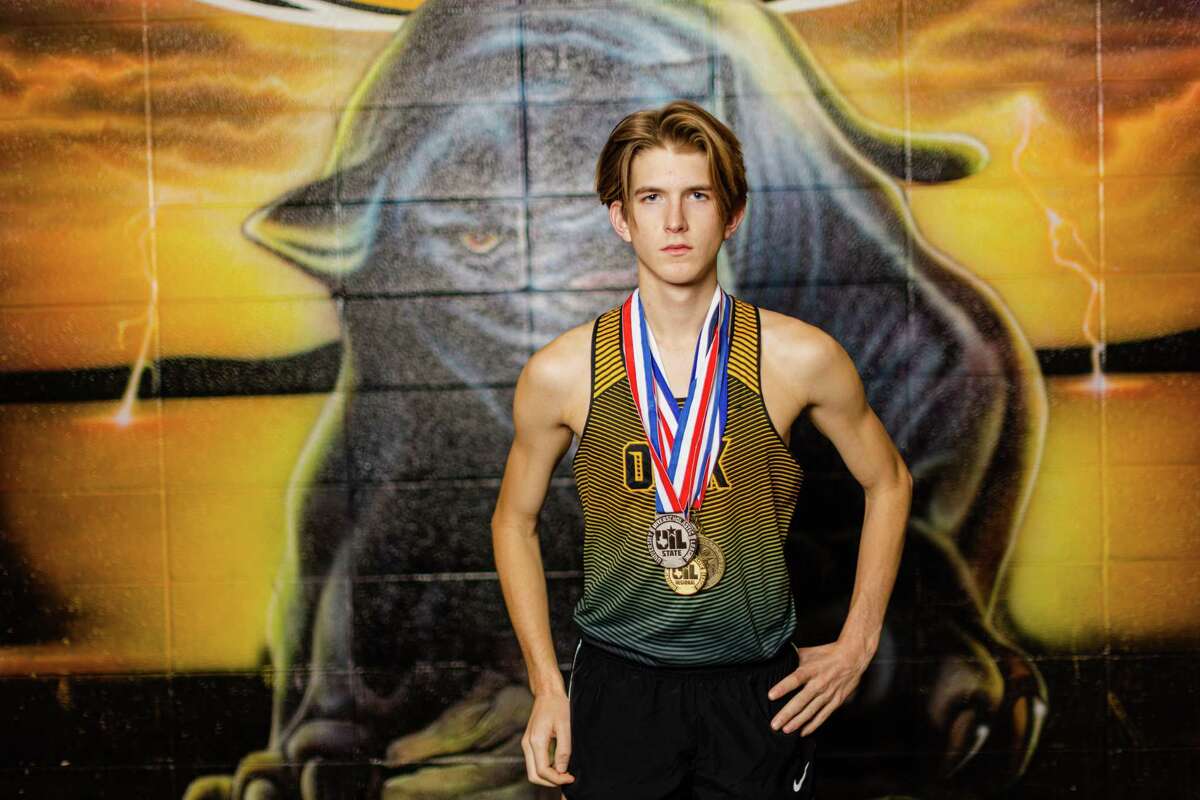 Jack Boyd pose with his UIL medals for a portrait in front of Klein Oak Panthers school mural during the All-Greater Houston boys cross country runner of the year photoshoot at the Klein Oak High School, Monday, November 21, 2022, in Spring.