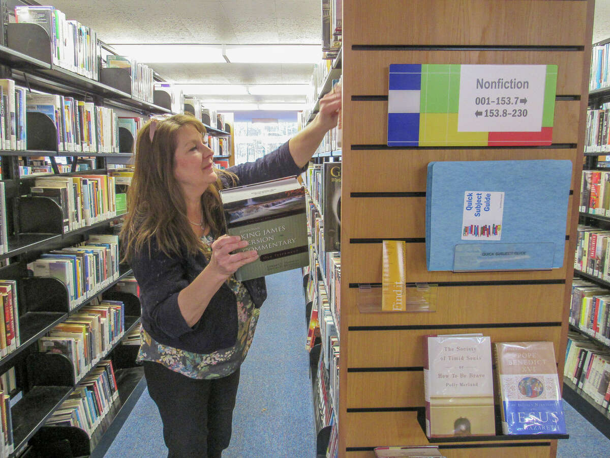 A librarian organizes books on Nov. 17, 2022 at the Grace A. Dow Memorial Library.