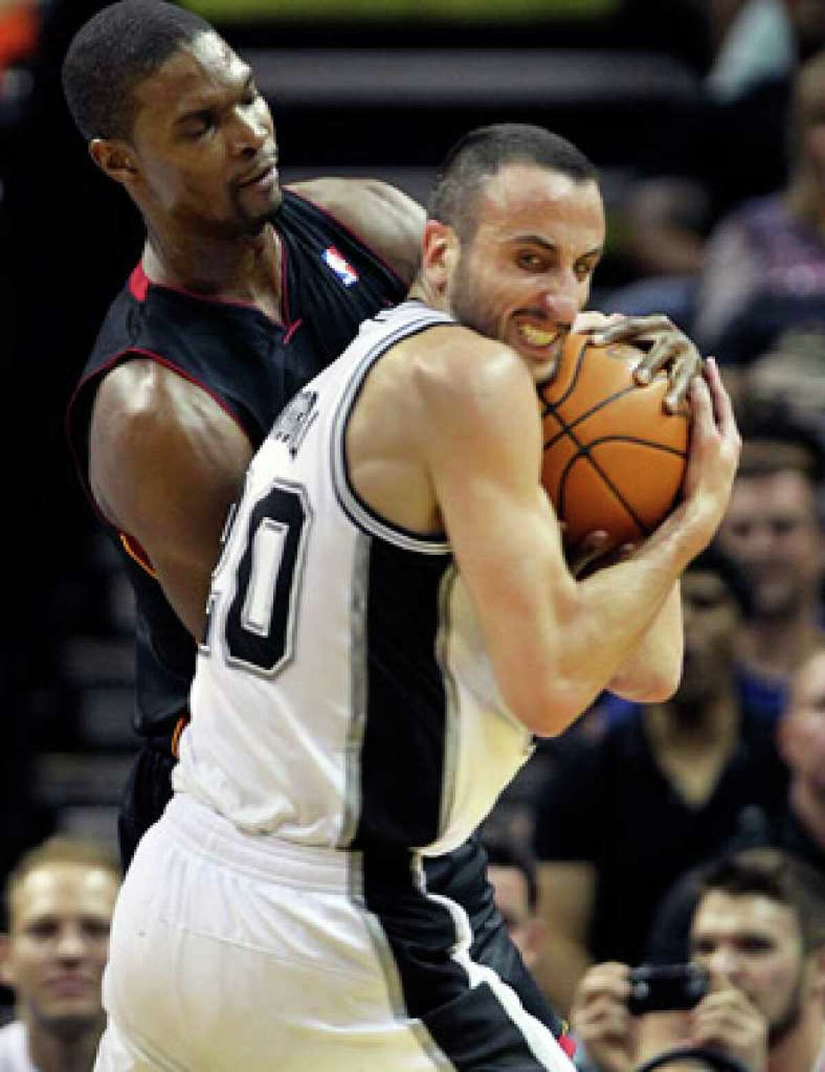 Spurs guard Manu Ginobili rips the ball away from Chris Bosh of the Miami Heat in the first half Saturday night.