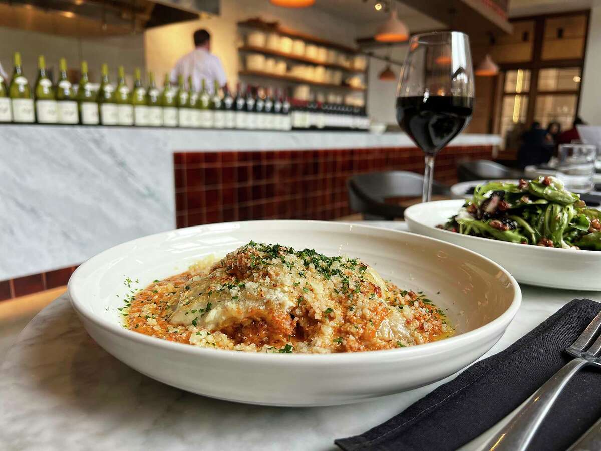 Lasagna Bolognese, Sicilian red wine and a house salad with goat cheese and blackberries are part of the rustic Italian restaurant experience at Arrosta at the Pearl in San Antonio.