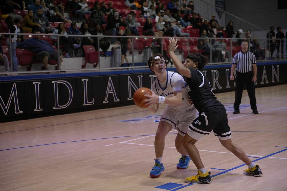 Midland Christian's Andrew Fox looks to shoot while being defended by Odessa Permian's Ben Saldivar during a Nov. 21 basketball game at McGraw Event Center. 