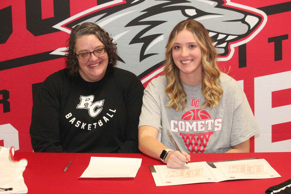 Christina Malackanich (right) of Reed City signs her national letter of intent on Monday to play women's basketball at Olivet College. Pictured at left is her mother, Lisa Blythe.