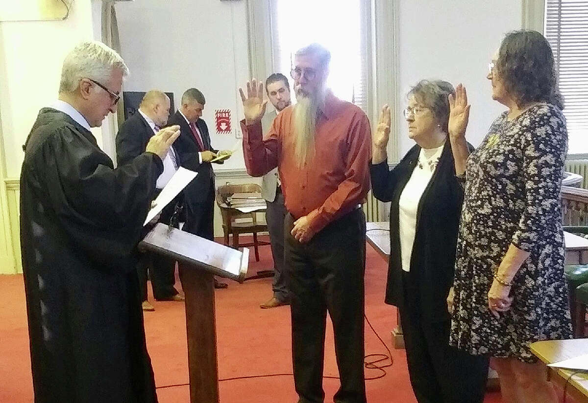Judge Jeffery Tobin (from left) swears in Dean Miles, Pat Pennell and Judy Dillard for the Morgan County CASA program. The program provides advocates for abused and neglected children in the court system.
