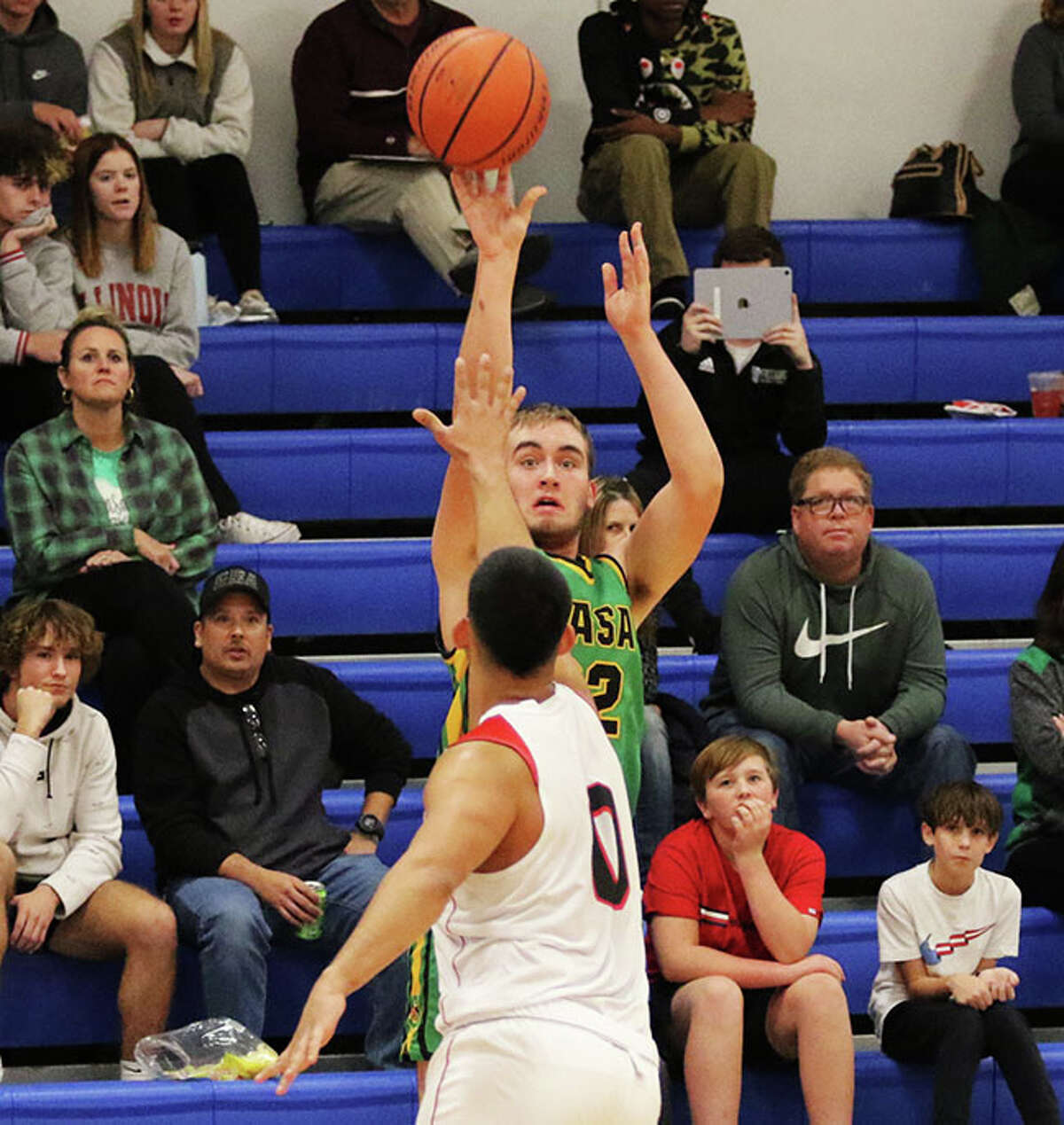 Southwestern's Ryan Lowis shoots over Gateway Christian Academy's Isaac Salas to make one of his four 3-pointers in the first half Monday night in the Hoopsgiving Classic at Roxana.