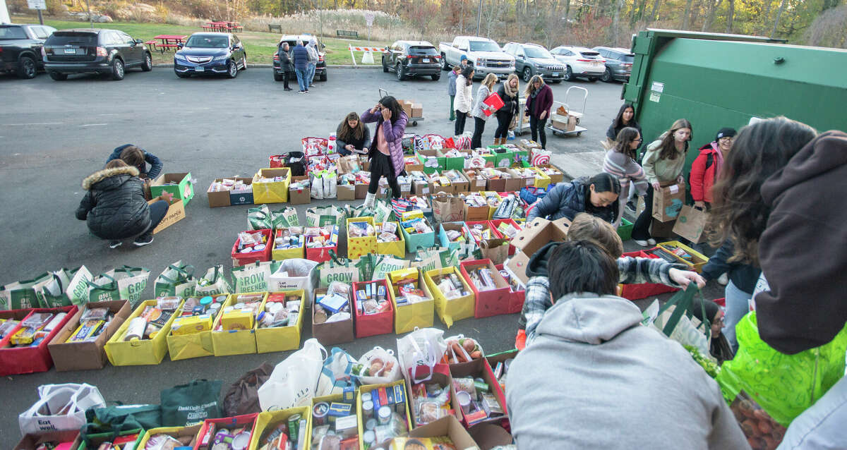 Volunteers from Greenwich High School fill bags and boxes with groceries Monday, November 21, 2022. The school's Roots and Shoots club holds a food drive annually to provide Thanksgiving nourishment.