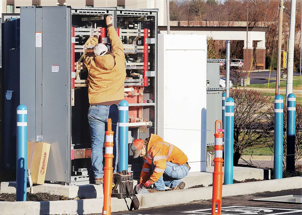 John Badman|The Telegraph Workers from Reinhold Electric, Inc. in St. Louis wire up the control box for the new EVgo Fast Charging station on the Homer Adams Parkway in Alton. 