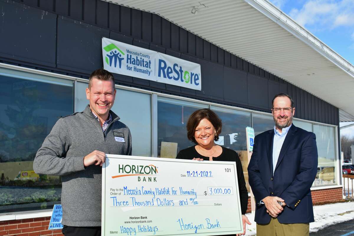 Horizon Bank of Big Rapids representatives Chad Nastoff (left) and Tom Rowland (right) pose for a photo presenting a $3,000 donation to the Mecosta County Habitat For Humanity and its executive director Barbara Seabolt (center) which is set to support its housing projects. 