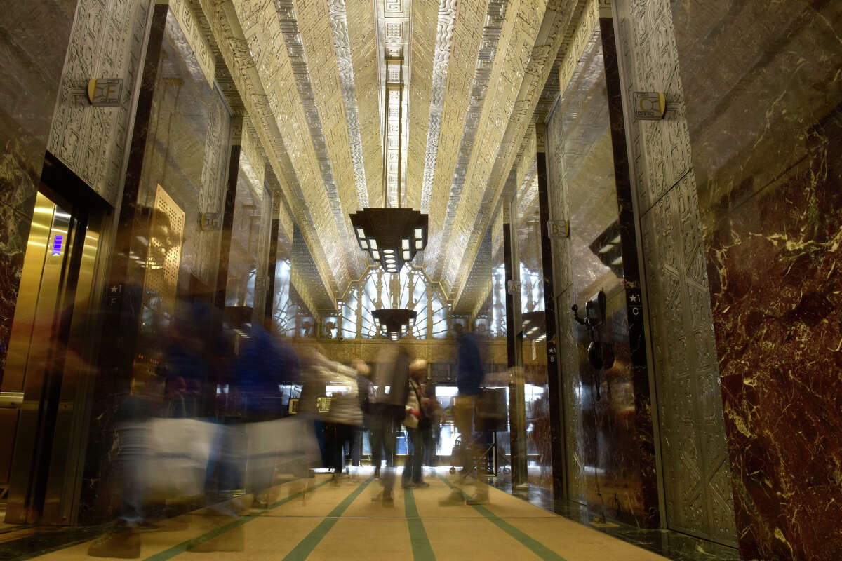 People flow in and out of the many elevators inside the lobby of 450 Sutter St., on Tuesday, Nov. 22, 2022. 