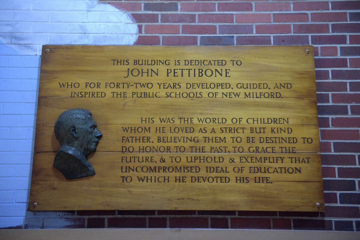 John Hunter Pettibone, of Bethel, with his daughter-in-law Susan Pettibone, of New Milford, in the John Pettibone Community Center, a former New Milford School building named after his grandfather John Pettibone. The plaque on the wall includes a profile bust done by the artist Richard Case Pettibone, son of John Pettibone and father of John Hunter Pettibone. Tuesday, November 15, 2022, New Milford, Conn.