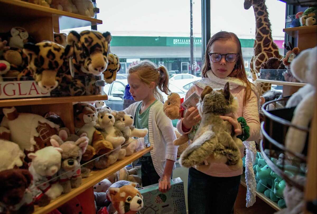 Sisters pick out stuffed animals at their local toy shop, Fundamentally Toys, as the shop prepares for a busy holiday season on Tuesday November 22, 2022.