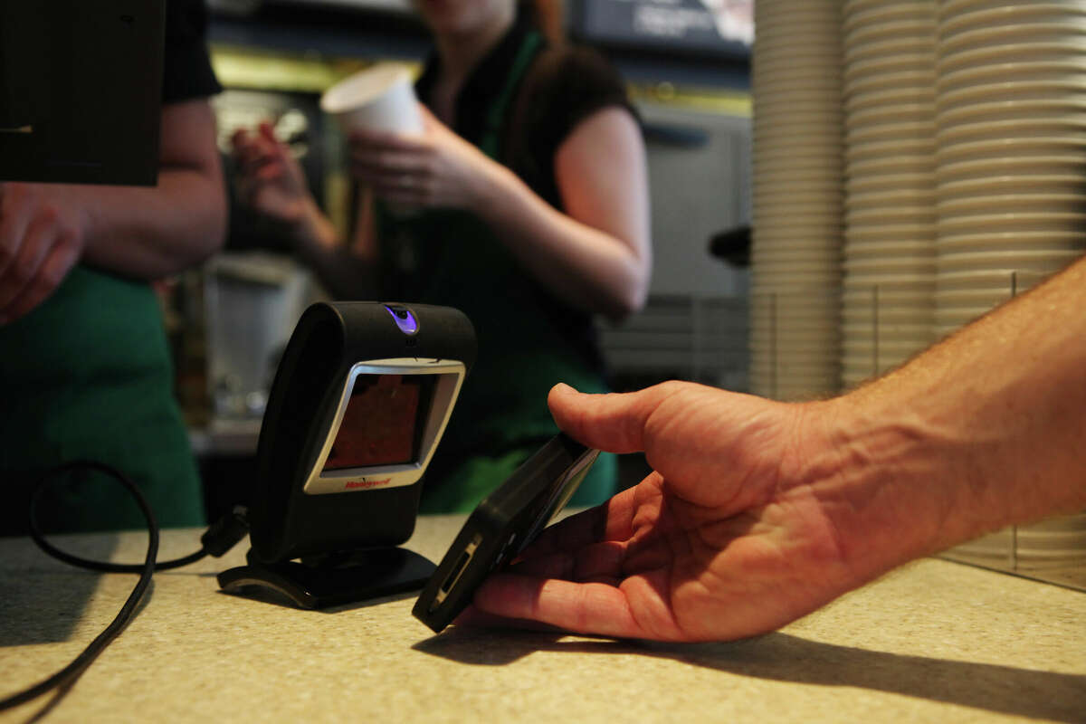 A Starbucks customer uses the Starbucks iPhone app to pay for a coffee.