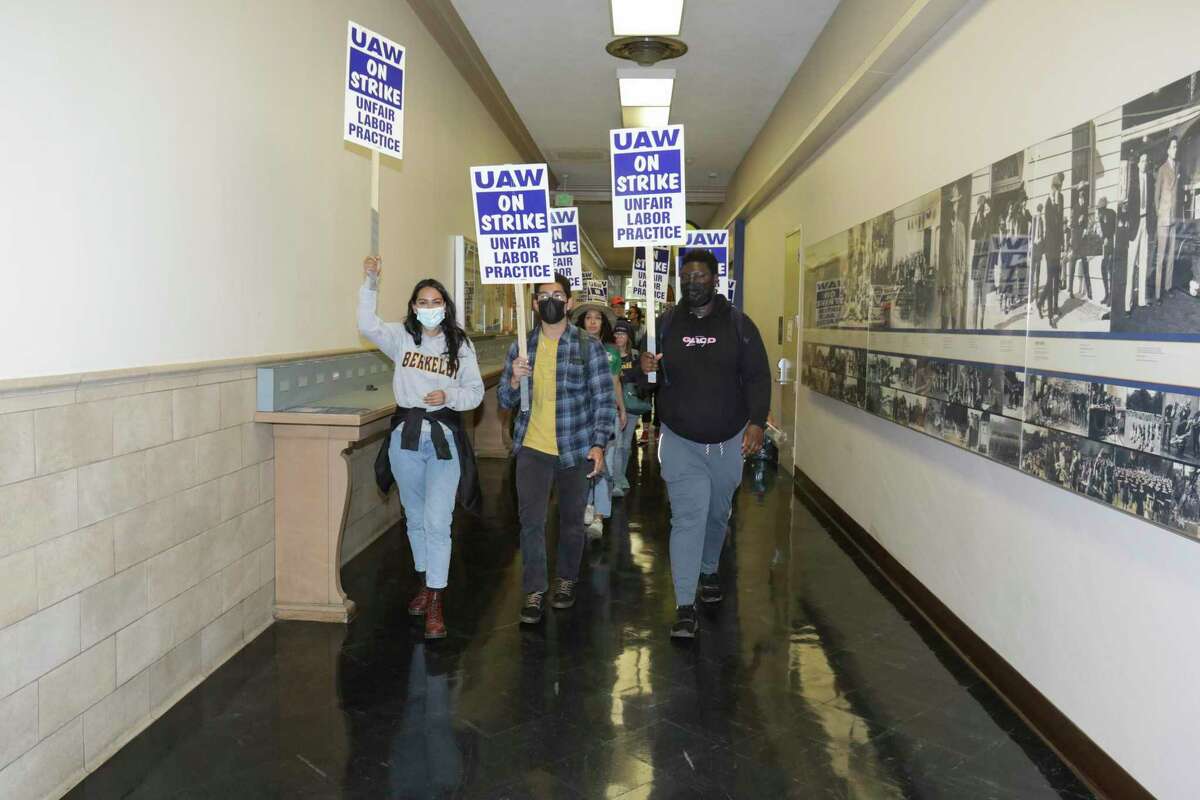 Striking UC workers march through Sproul Hallat UC Berkeley. State employment officials have filed seven complaints against UC in its negotiations with the union representing the strikers.