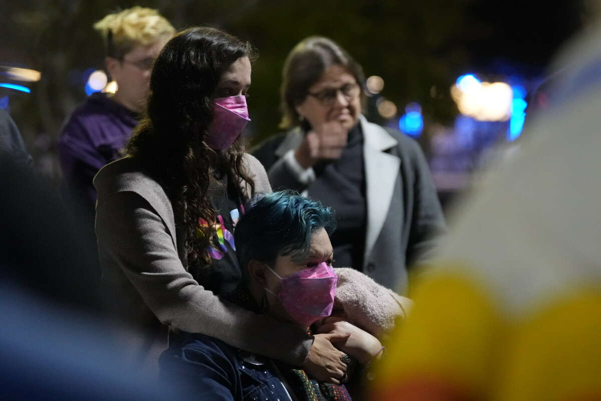 Kelsey Falls puts her hand on the shoulder of her partner Angela Horst as they listen to speakers during a vigil for the shooting victims at Club Q in Colorado at MacGregor Park on Tuesday, Nov. 22, 2022 in Houston.