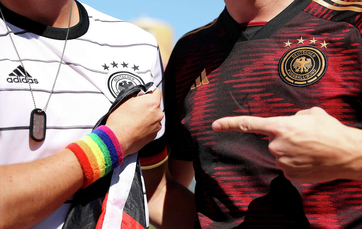 Germany fans pose for a photo as they wear a Rainbow wristband as the German Interior Minister Visits DFB's Mobile Fan Embassy on November 22, 2022 in Doha, Qatar.