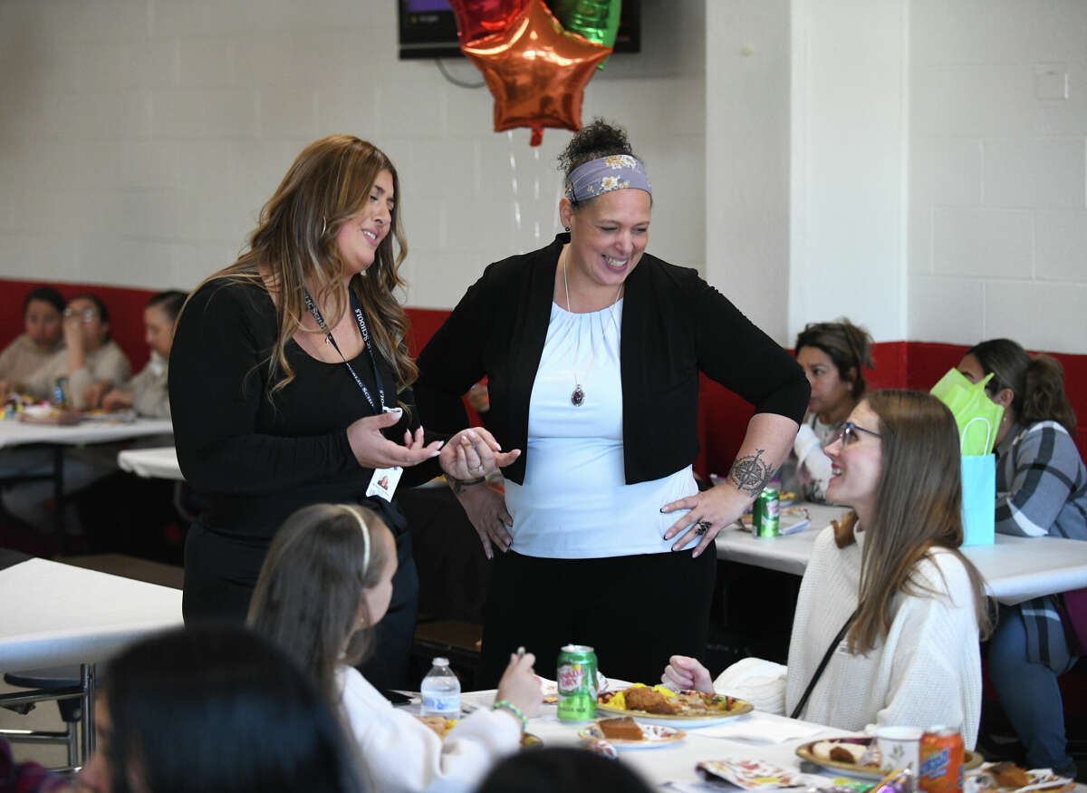 Event organizers Andrea Cardillo, left, and Elba Sims chat with families during the Thanksgiving lunch for newly immigrated students at Turn of River Middle School in Stamford, Conn. Wednesday, Nov. 23, 2022. Families of students who recently moved to Stamford from outside of the United States enjoyed a Thanksgiving meal while learning about the meaning of Thanksgiving and hearing students' presentations about what they're thankful for.