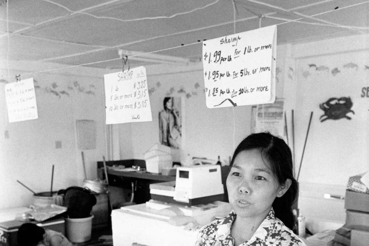 08/1979 - Tam Nguyen, 35, explains from behind the counter of her brother's fish house in Seabrook that her people feel welcome in their new home on Galveston Bay, but don't understand many of the laws and customs .