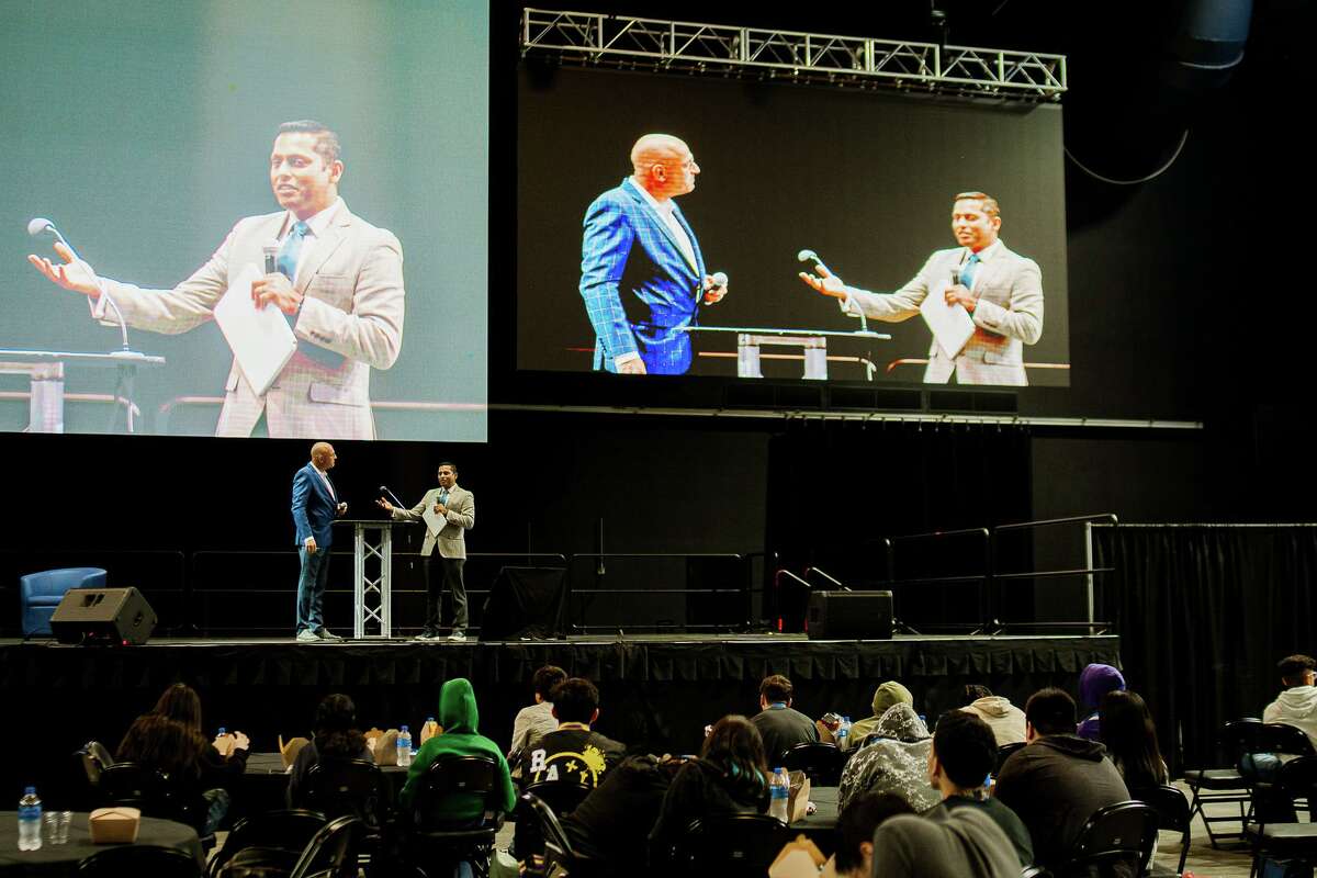 Valmiki Mukherjee — right, founder and chairman of the Dallas-based Cyber Future Foundation, the organization that brought the Cyber Future Summit 2022 to Port San Antonio for the first time in October — wants DeLorean Motor Co. CEO Joost de Vries welcomed to the stage for his remarks.