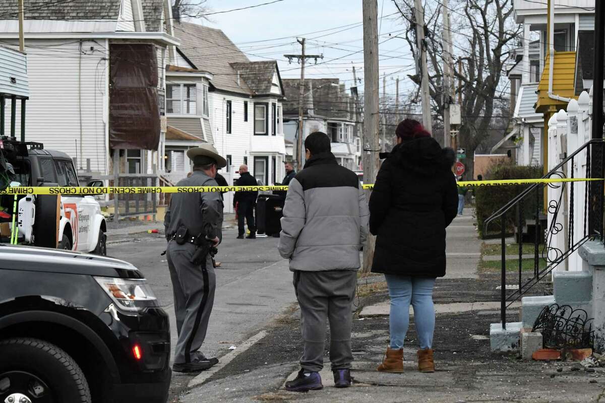 Bystanders wait as police investigate the scene of a fatal shooting on Odell Street near Brandywine Avenue on Wednesday, Nov. 23, 2022, in Schenectady, N.Y.