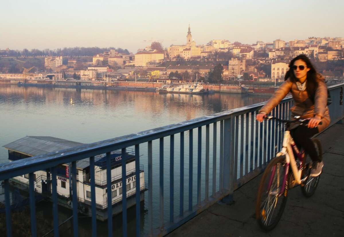 A woman rides a bicycle on Danube Bridge in Belgrade, Serbia, in December 2015.
