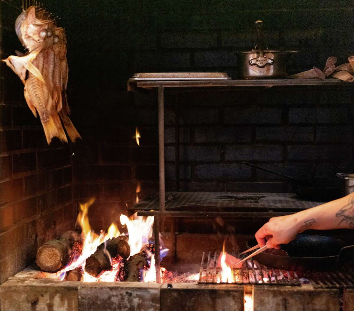 晚宴期间，岩鱼悬挂在木质烤架上方。
