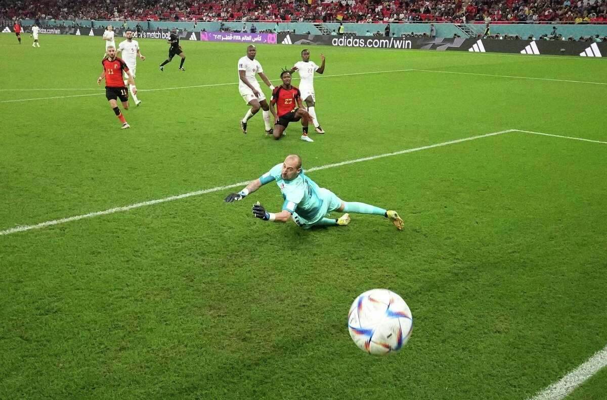 Michy Batshuayi (center, kneeling) scores Belgium’s only goal past goalkeeper Milan Borjan in the 44th minute of its 1-0 win over Canada.
