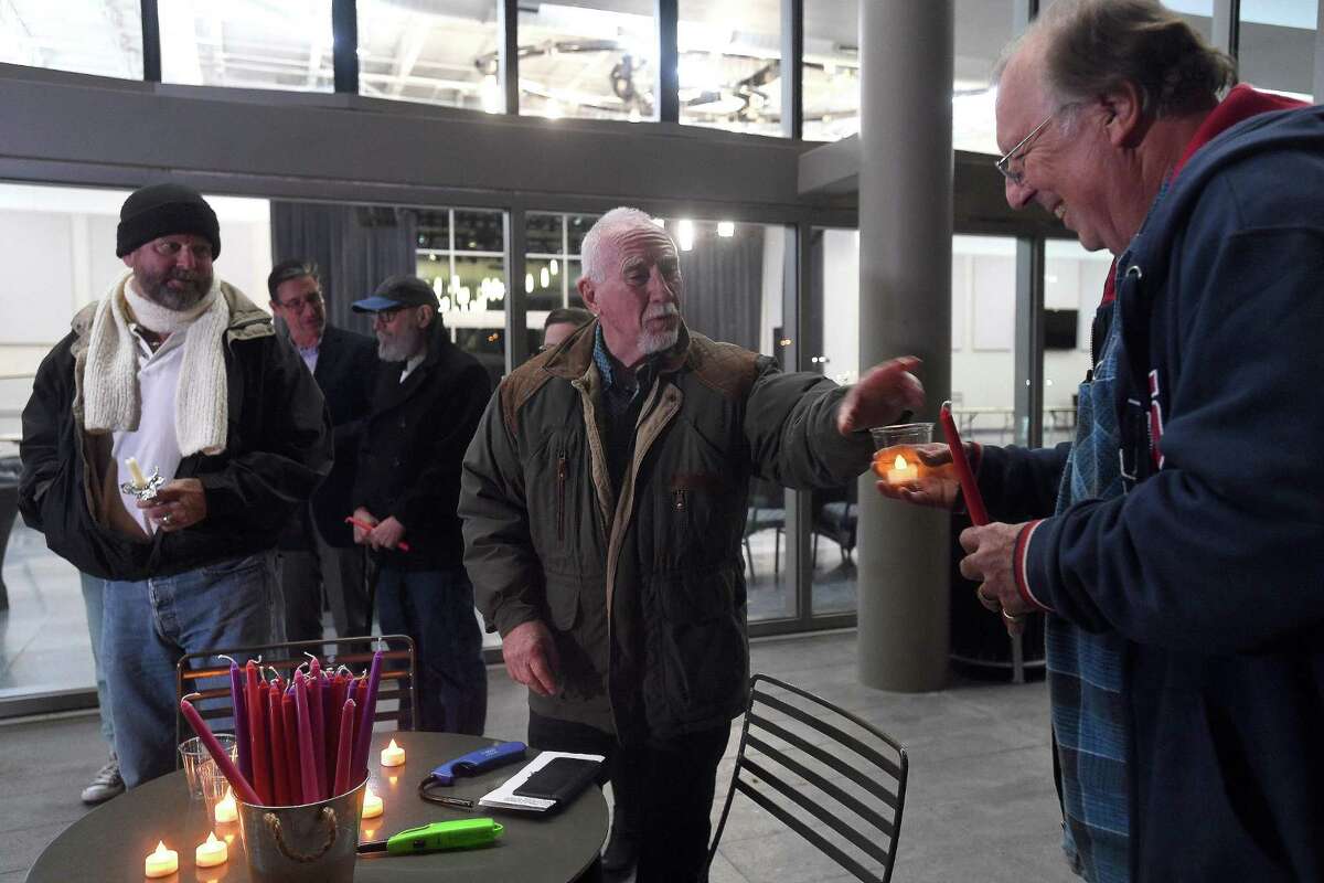 Robert Clark passes out a candle as members of the community gathered at the Event Centre for a candlelight vigil to mourn the victims of Saturday's fatal mass shooting at Club Q in Colorado Springs. Photo made Tuesday, November 22, 2022 Kim Brent/Beaumont Enterprise