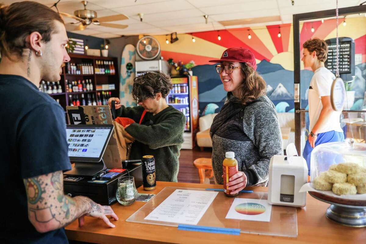 Barista Wade Garrett assists Colleen Clark at Ocean Beach Cafe in San Francisco. Owner Joshua James started out trying to amass the country’s largest collection of nonalcoholic wine and spirits, but learned that there are too many options to make that realistic.