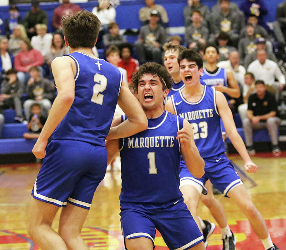 Marquette's Parker Macias (1) and Jack Spain rush in to congratulate Braden Kline after Kline's fourth 3-pointer in the third quarter led to a Jersey timeout Wednesday night at the Hoopsgiving Classic at Roxana.