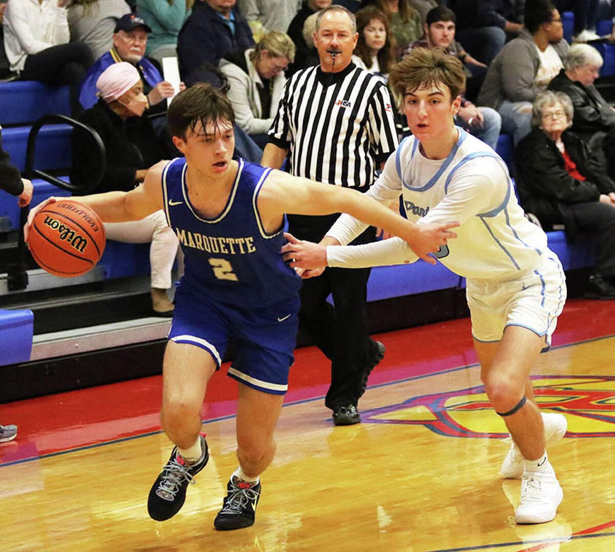 Marquette Catholic's Braden Kline (left) drives past Jersey's Jaxon Brunaugh in the first half Wednesday night at the Hoopsgiving Classic at Roxana. Both players had career scoring nights, with Kline getting 31 and Brunaugh getting 23.