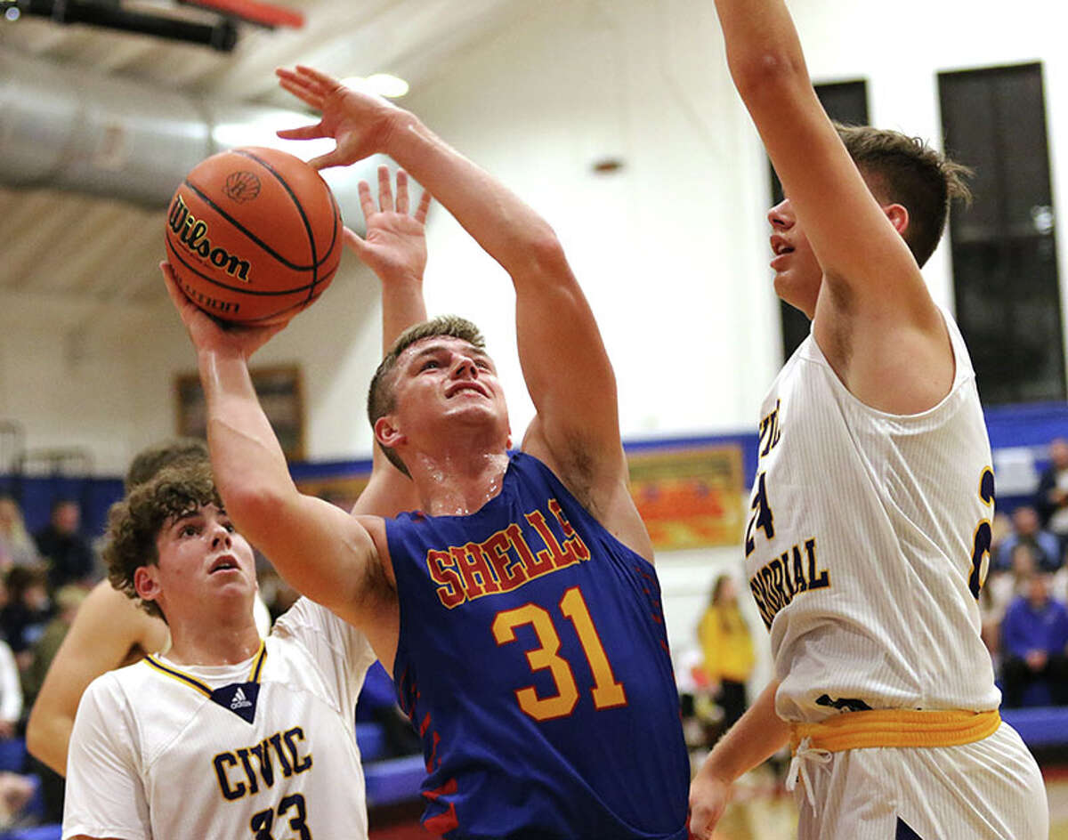 Roxana's Evan Wells (31) looks to put up a shot between CM's August Frankford (left) and Sam Buckley on Wednesday night at the Hoopsgiving Classic at Roxana.