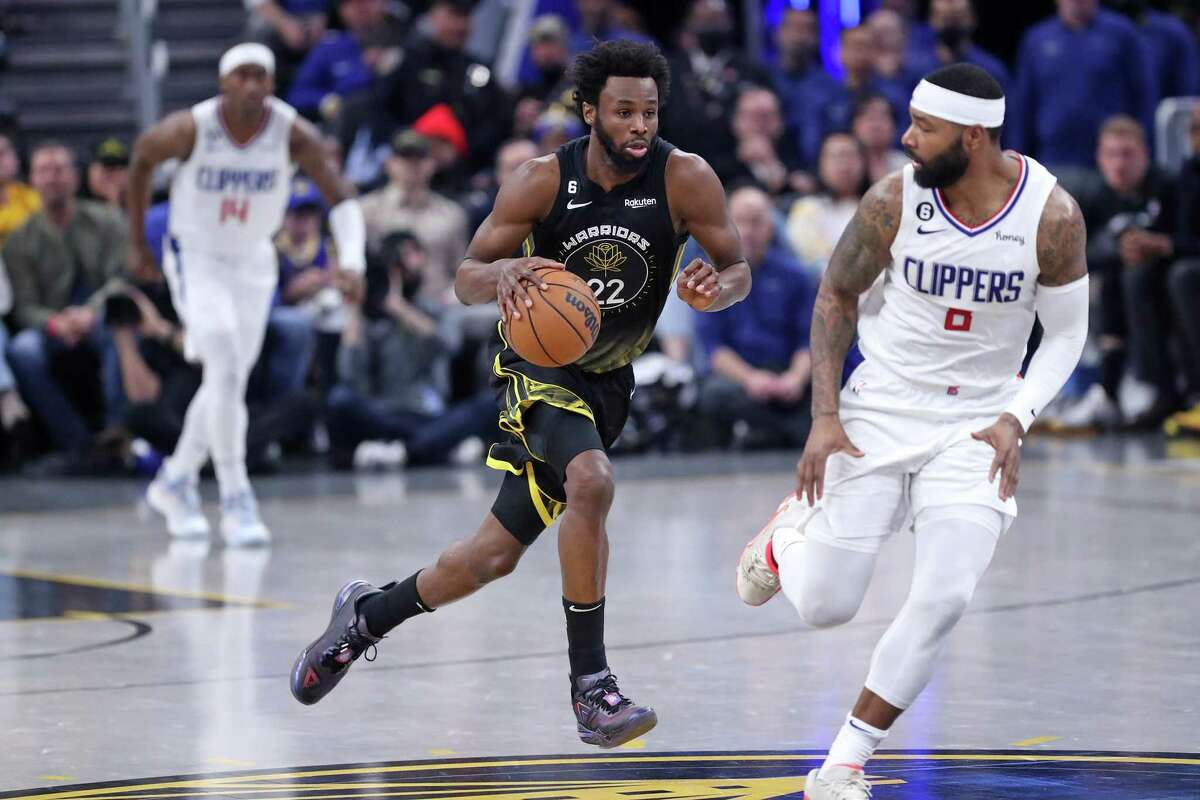 Golden State Warriors’ Andrew Wiggins dribbles up court against Los Angeles Clippers’ Marcus Morris, Sr. in 2nd quarter during NBA game at Chase Center in San Francisco, Calif., on Wednesday, November 23, 2022.