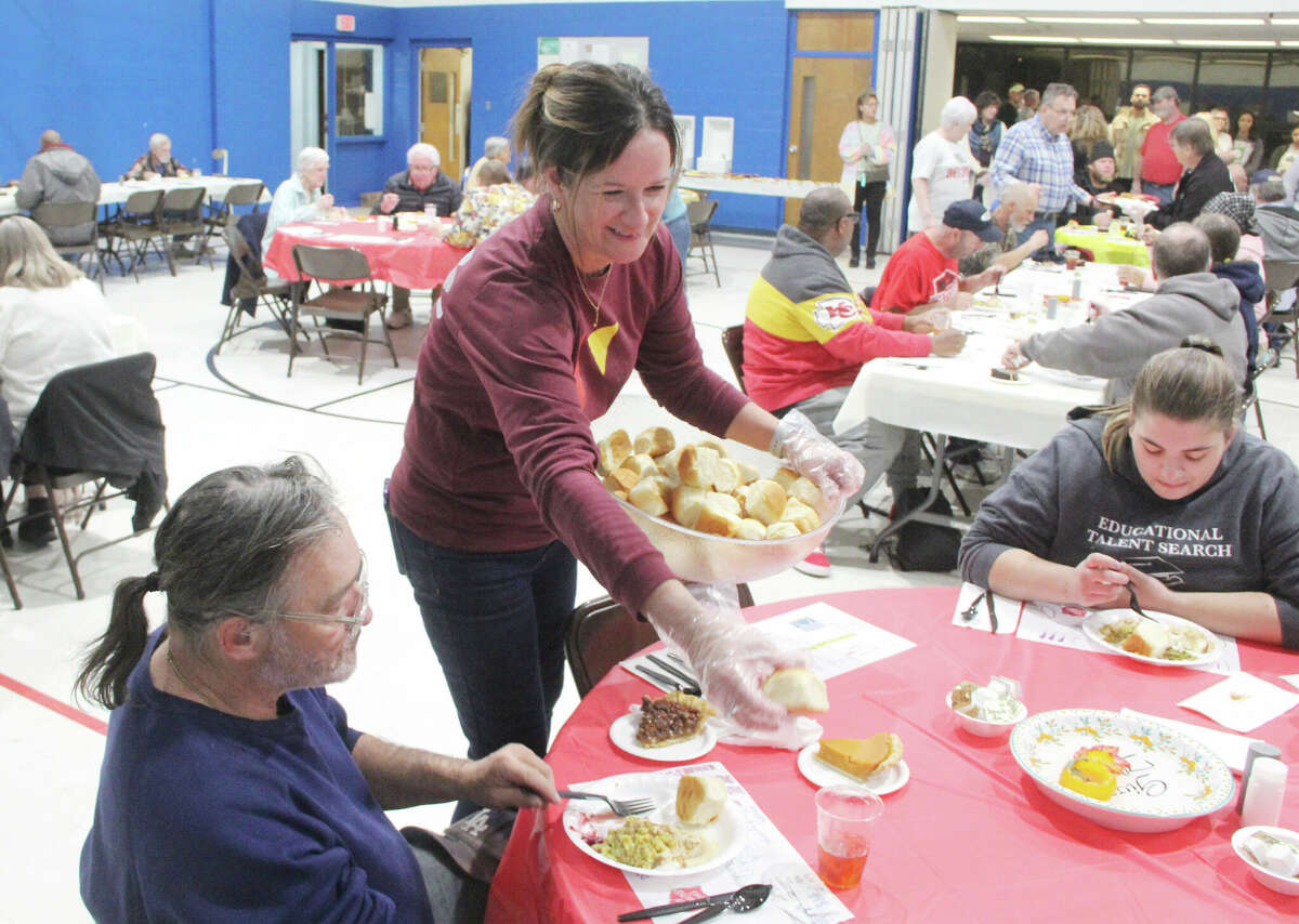 Julia Rothe serves rolls during the annual Thanksgiving Dinner put on by Abundant Life Community Church and the Salvation Army Wednesday evening at the Salvation Army’s Alton Corps Community Center on Alby. About 200 people came out and were served by approximately 40 volunteers from the church.